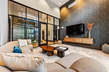 A modern living room with a flat screen TV mounted on the wall.